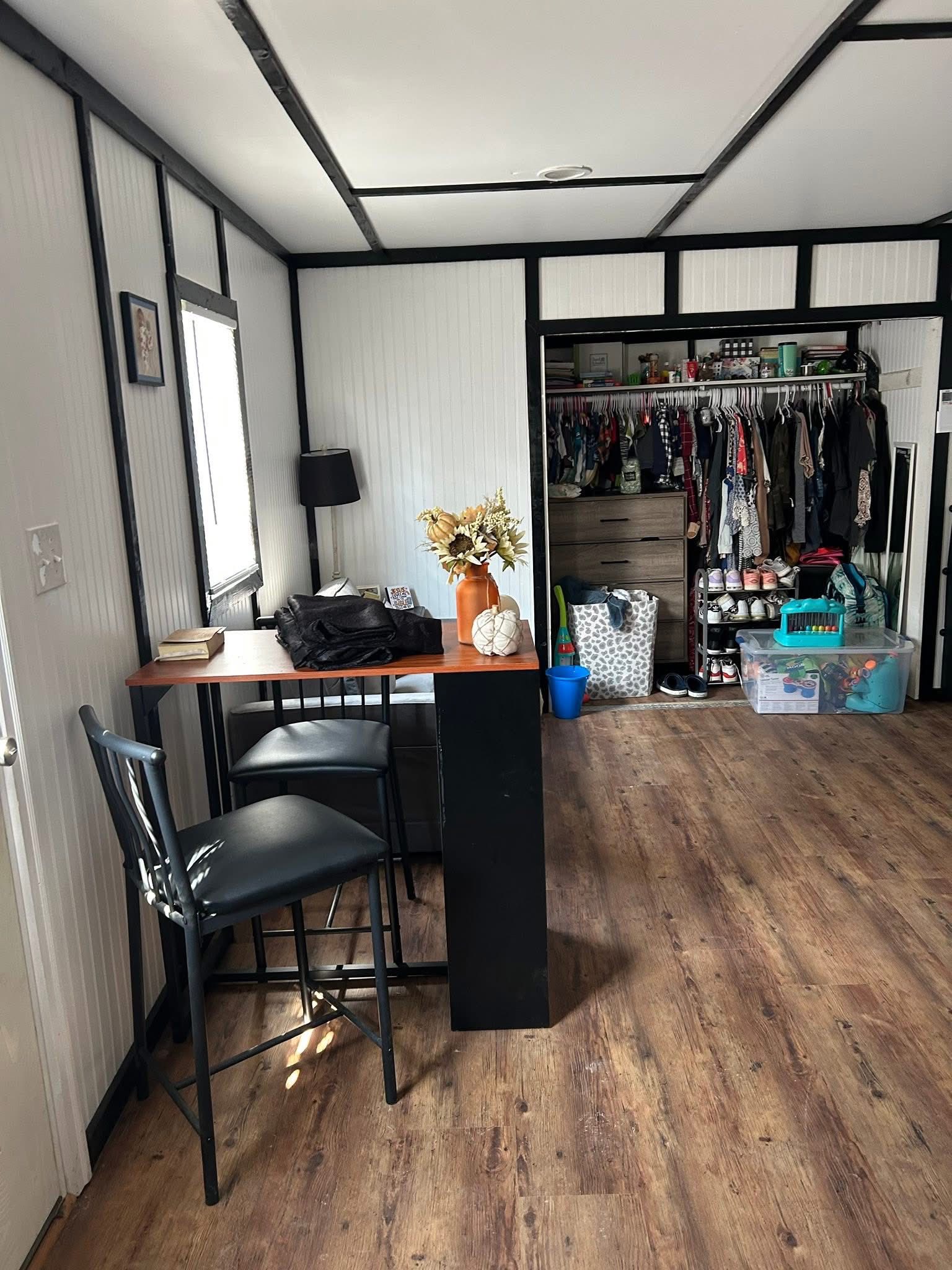 Tiny house dining area with bar table, chairs, and closet storage